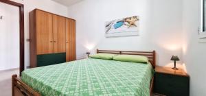 マリーナ・ディ・ラグーザにあるCasa SantaBarbaraのベッドルーム1室(緑のベッド1台、木製キャビネット付)