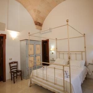 um quarto com uma cama de dossel e uma cadeira em Lo Scrigno Barocco em Lecce
