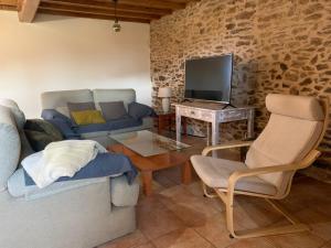 uma sala de estar com um sofá e uma televisão em VUT Rural - Boente em Arzúa