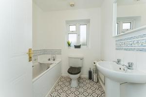 a white bathroom with a sink and a toilet at AMAZING CONTRACTOR HOUSE 3 bedroom warm modern house free secure off road parking, wifi & sky sleep upto 8 guest s in Aintree