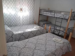 een slaapkamer met 2 stapelbedden en een raam bij El Refugio Yunquera, Málaga. in Yunquera