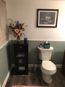 a bathroom with a toilet and a vase of flowers at Hope Bed and Breakfast in Canton +31 photos