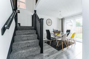 - un escalier dans le salon avec une table et des chaises dans l'établissement AMAZING CONTRACTOR HOUSE 3 bedroom warm modern house free secure off road parking, wifi & sky sleep upto 8 guest s, à Aintree