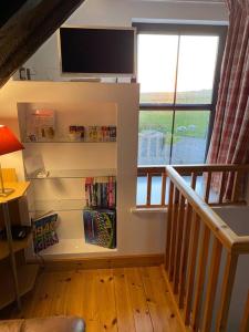 Habitación con estante de libros y ventana en Sea View ,Cottage2 Dunnetbay accommodation, en Castletown