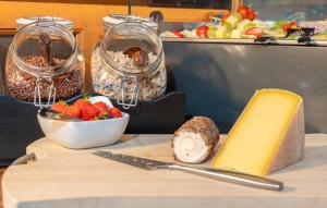 una tavola con un tagliere con una ciotola di fragole e formaggio di Gasthof Rieder Stubn Hotel#Restaurant#Pinseria a Ried im Oberinntal