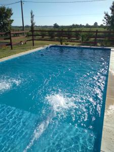 a swimming pool with blue water in front of a fence at Tierra Adentro Colón in Colón