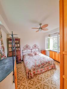 1 dormitorio con 1 cama y ventilador de techo en L'uliveto di Santa con piscina, en Santa Margherita Ligure