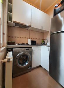 eine Küche mit einer Waschmaschine und einem Kühlschrank in der Unterkunft Luk's Central Residence in Constanţa
