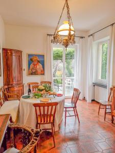 una sala da pranzo con tavolo, sedie e lampadario pendente di L'uliveto di Santa con piscina a Santa Margherita Ligure