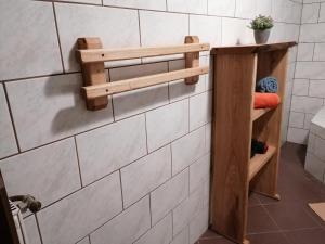 baño con una estantería de madera en una pared de azulejos en Apartma, en Selnica ob Dravi