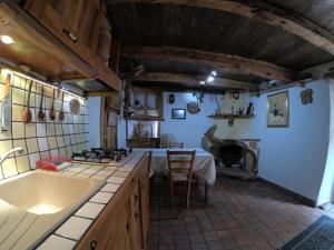 a kitchen with a table and a stove top oven at Sa domu 'eccia in Urzulei
