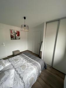 een slaapkamer met een bed en een kroonluchter bij L'ALPIN in Bourg-Saint-Maurice