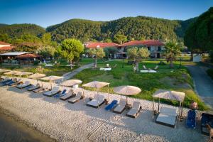 a row of chairs and umbrellas on a beach at Anna Karra Studios & Apartments in Vourvourou