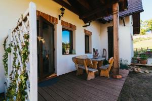 a porch of a house with a table and chairs at Apartamenty na Pastwisku in Szymbark