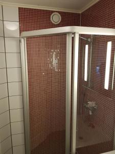 La salle de bains est pourvue d'une douche et de carrelage rouge. dans l'établissement Fjærland Våteviksvegen 17, à Bøyum