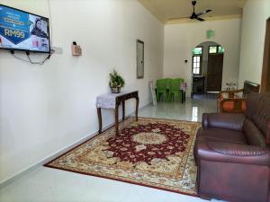 sala de estar con sofá y mesa en Sofea Homestay, en Batu Rakit