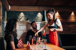 a woman pouring a glass of wine at a table at Landgasthof & Hotel beim Lipp in Roßhaupten