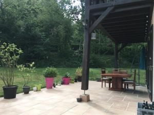 une terrasse avec une table en bois et des plantes en pot dans l'établissement Studio à la campagne, à Bouloire