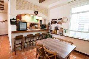a kitchen and dining room with a wooden table and chairs at THEDAY B&B in Magong