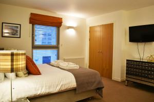 a bedroom with a bed and a flat screen tv at Cannon Point BW7 in Fort Augustus