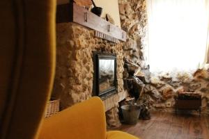 sala de estar con pared de piedra y chimenea en Casa Rural Los Agüelos, en Mazuecos