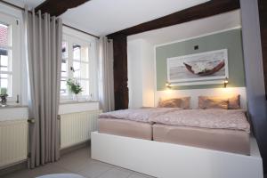 a bedroom with a bed and two windows at Wohnen auf der historischen Stadtmauer im Herzen von Detmold in Detmold