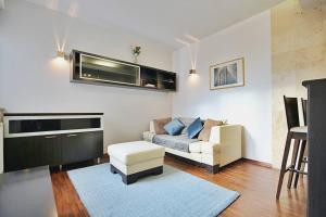 sala de estar con sofá y silla en Parkowy Apartament, en Wroclaw