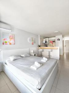 a white bedroom with a large bed in a room at Sunshine Borinquen in Playa de las Americas