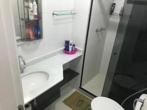 ein weißes Badezimmer mit Waschbecken und Dusche in der Unterkunft Loft Reserva do Sahy - Mangaratiba in Mangaratiba