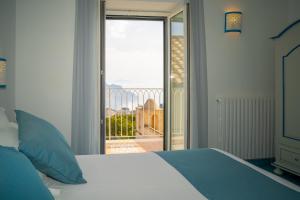 a bedroom with a bed and a view of a balcony at Ravello Dream Charming House in Scala