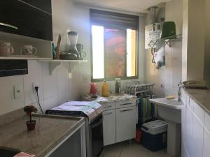 eine kleine Küche mit Spüle und Fenster in der Unterkunft Loft Reserva do Sahy - Mangaratiba in Mangaratiba + 14 Fotos