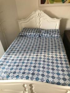 ein weißes Bett mit einer blau-weiß karierten Matratze in der Unterkunft Loft Reserva do Sahy - Mangaratiba in Mangaratiba
