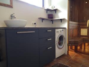 a bathroom with a sink and a washing machine at Metsaräägu Wellness in Ulendi