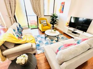 ein Wohnzimmer mit 2 Sofas und einem TV in der Unterkunft Luxury Casa - Indigo Sea View Apartment JBR Beach 2BR in Dubai