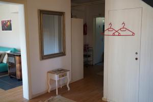 Cette chambre dispose d'un couloir avec un miroir et une table. dans l'établissement Ferienwohnung am Waldrand, Hitzacker, à Hitzacker