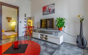 a living room with a television and a red table at Apartman 39 in Pula