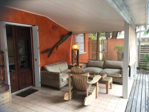 a patio with a couch and a table and chairs at Maison Saint Exupéry avec piscine in Le François