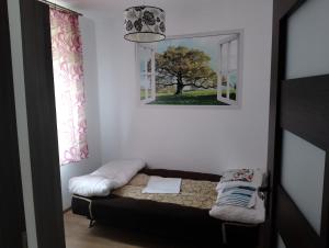 a small room with a bed and a mirror at Dom nad jeziorem - MAZURY in Szczytno