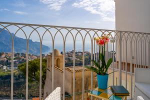 Un balcón con una mesa con un jarrón de flores. en Ravello Dream Charming House, en Scala