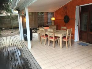 a wooden table and chairs on a patio at Maison Saint Exupéry avec piscine in Le François