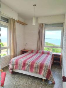 - une chambre avec un lit et 2 fenêtres dans l'établissement Apartamento en primera línea con vista al mar, à Punta del Este