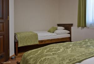 1 dormitorio con 2 camas con sábanas verdes en Vincze Vendeghaz, en Kiskunhalas