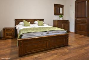 1 dormitorio con cama de madera con sábanas verdes en Vincze Vendeghaz, en Kiskunhalas