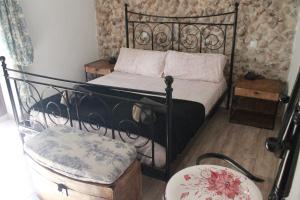 a bedroom with a black bed and a chair at Casa Rural Los Agüelos in Mazuecos