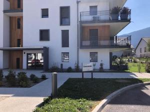 a white building with a sign in front of it at Appartement neuf au calme proche du lac in Saint-Jorioz