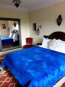 a bedroom with a blue bed and a mirror at Riad TANJIL in Casablanca