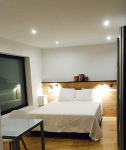 a bedroom with a large white bed and a table at Calle Mayor 21 VUT1222AS in Llanes