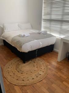 a bed in a bedroom with a rug on the floor at 7 on Sachs in Cape Town
