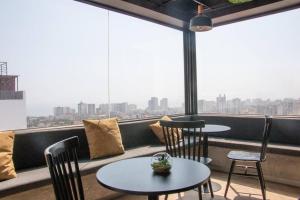 a restaurant with two tables and chairs and a large window at Departamento de estreno Lima vip in Lima