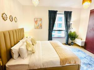 ein Schlafzimmer mit einem großen weißen Bett mit Kissen in der Unterkunft Luxury Casa - Indigo Sea View Apartment JBR Beach 2BR in Dubai